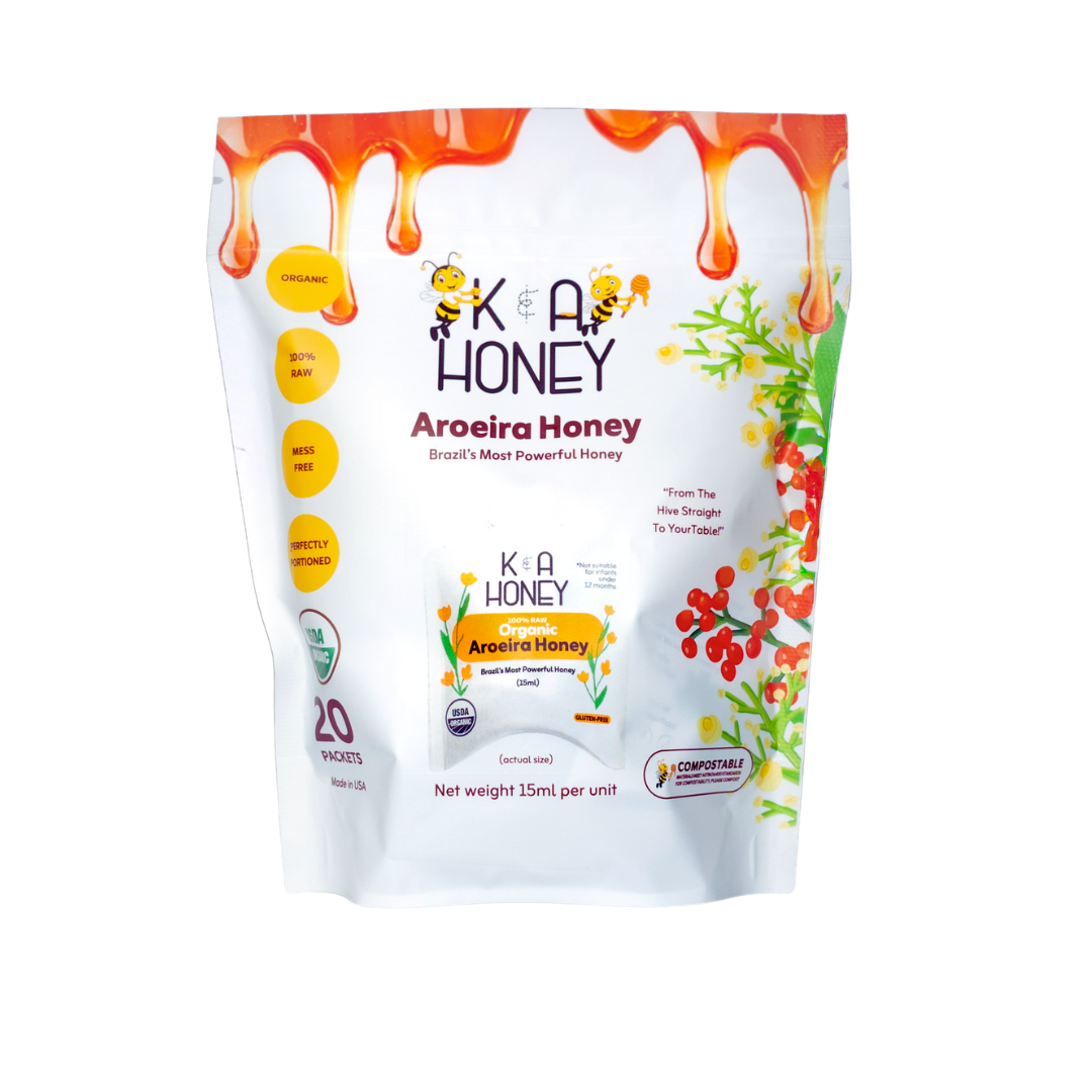 K&A Honey box labeled 'Aroeira Honey – Brazil's Most Powerful Honey'; decorated with honey drips and botanical graphics; highlights USDA Organic, gluten-free, compostable, and 100% raw; contains 20 mess-free 15ml packets.